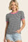 woman wearing a black and white striped t-shirt with pink trim and puff sleeves, paired with denim shorts