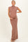 woman wearing a sleeveless mauve maternity gown with a high neckline and holding her baby bump