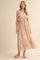 woman wearing a pink floral maxi dress with adjustable tie straps and a tiered skirt