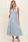 woman wearing a light blue and white striped maternity dress with a v-neck and shoulder ties, featuring pockets
