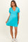 woman wearing a turquoise maternity dress with a v-neck and short sleeves, showcasing her baby bump