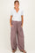 woman wearing a light grey maternity henley top and loose mauve maternity lounge pants with pockets