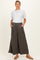 woman wearing a white short sleeve top and dark green maternity wide-leg trousers with pockets