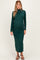 woman wearing a dark green long sleeve maternity dress with a fitted silhouette and a high neckline, showing her baby bump
