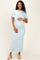 woman wearing a light blue ribbed maternity dress and holding her baby bump