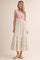 woman wearing a floral print maxi dress with a smocked bodice and ruffled hem, posing against a neutral background