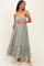 woman wearing a gray striped maternity maxi dress with a ruffled hem and holding her baby bump