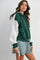 woman wearing a green and gray color block hoodie styled with plaid shorts