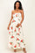 woman wearing a floral maternity maxi dress with spaghetti straps and holding her baby bump