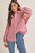 woman wearing a red and white striped oversized button-up shirt with balloon sleeves and blue jeans