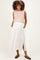 woman wearing a blush pink knitted crop top and a white maxi skirt with pockets