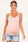 woman wearing a light pink maternity tank top with scalloped straps, showcasing her baby bump and styled with denim shorts