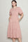 woman wearing a pink floral midi dress with puff sleeves and side pockets