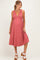 woman wearing a dusty rose sleeveless maternity dress with a deep V-neck and a flowing skirt, showcasing her baby bump