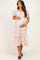 woman wearing a pink floral maternity dress with short puff sleeves and a baby bump