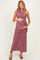 woman wearing a mauve one-shoulder maternity dress, highlighting her baby bump with a ruched design