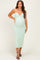 woman wearing a mint green strapless maternity dress with a twist detail and a visible baby bump