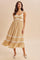woman wearing a yellow floral sundress with lace detailing and a flared hem, standing against a neutral background