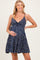woman wearing a navy blue floral maternity dress and gently cradling her baby bump