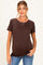woman wearing a brown short sleeve maternity top and fitted jeans with a slight baby bump visible