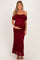 woman wearing a burgundy lace off-the-shoulder maternity dress showing her baby bump