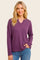 woman wearing a purple long sleeve waffle knit top with a v-neck and relaxed fit, styled with blue jeans