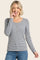 woman wearing a navy and white striped long sleeve henley top with button details and smiling