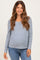 woman wearing a blue and white striped maternity top with buttons and a visible baby bump