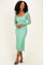 woman wearing a mint green lace long sleeve dress with a fitted silhouette and midi length