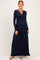 woman wearing a navy blue long sleeve maternity maxi dress with a fitted bodice and flowing skirt, showcasing her baby bump