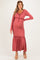 woman wearing a dusty rose maternity maxi dress with long sleeves and a ruffled hem, showing her baby bump