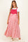 woman wearing a red and white striped maternity maxi dress with adjustable straps over a white t-shirt and white sneakers