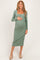 woman wearing a fitted sage green long sleeve maternity dress with a square neckline and holding her baby bump