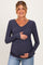 woman wearing a navy blue v-neck maternity top and holding her baby bump