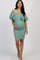 woman wearing a sage green off-the-shoulder ruffled maternity dress, holding her baby bump