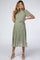 woman wearing a green floral print maternity dress with short sleeves and a tie waist, showcasing her baby bump