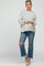 woman wearing a light grey knit maternity hoodie and distressed blue jeans with snakeskin flats