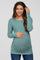 woman wearing a teal long sleeve maternity top with ruching and a visible baby bump