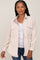 Woman wearing a cream corduroy button-down shirt over a white tank top and blue jeans
