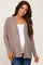 woman wearing a tan long sleeve maternity cardigan over a white top and showing her baby bump