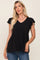 blonde woman wearing a black v-neck babydoll top with ruffle sleeves and blue jeans