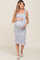 woman wearing a light blue floral maternity dress with ruffled straps and a visible baby bump