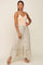 woman wearing a peach camisole and a mint green floral maxi skirt with a ruffled hem and front slit