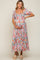 woman wearing a floral maternity maxi dress with puff sleeves and holding her baby bump