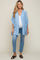 pregnant woman wearing a light blue frayed maternity kimono over a white top and blue jeans