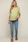 woman wearing a light green maternity top and blue skinny jeans, showing her baby bump