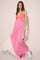 woman wearing a color-blocked pink and orange maxi dress with a deep v-neck and white panel, paired with white sneakers