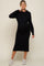 woman wearing a black maternity hoodie dress with a drawstring waist and a baby bump, paired with white sneakers