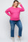 woman wearing a pink maternity plus long sleeve sweater and blue jeans, showcasing her baby bump