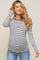 woman wearing a navy and white striped maternity top with long sleeves and a visible baby bump